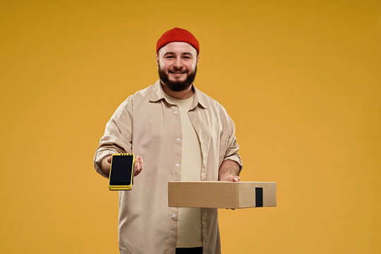 Courier holding a parcel and payment terminal against a yellow background