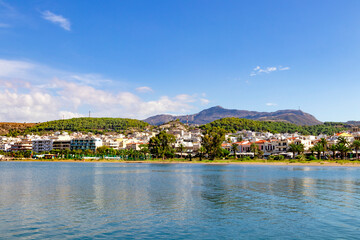Obraz premium A charming seaside town that boasts calm, inviting waters, lush green hills, and an endless clear blue sky above. Greece. Rethymnon.
