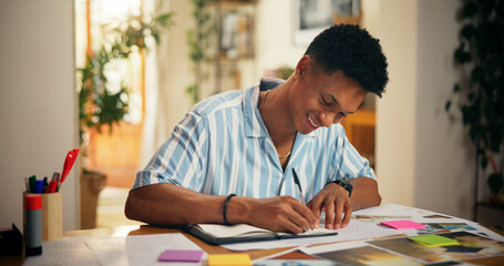 Naklejka premium Man, creative and happy with writing in home for planning vision board, goals timeline and manifestation. Poster, pictures and sticky notes for dream ideas, progress tracking or personal development