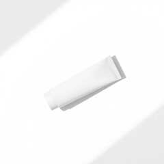 An overhead bird's-eye view of a realistic white matte tube mockup for a premium cosmetic product, displayed on a minimal white background with soft light.