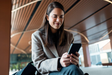 Entrepreneur woman checking her mobile phone indoors