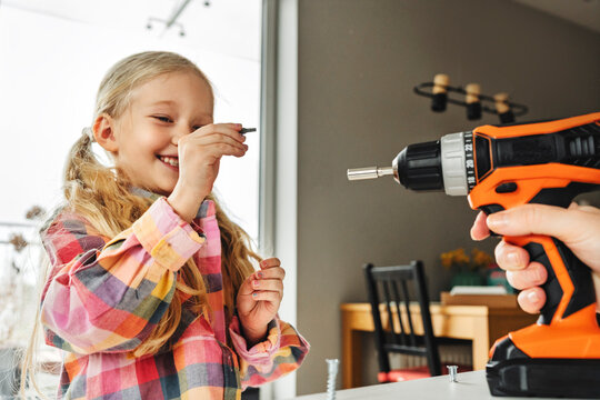 Father and daughter assembling furniture together at home