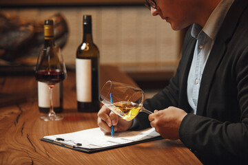Sommelier Writing Notes Beside Wine Bottle