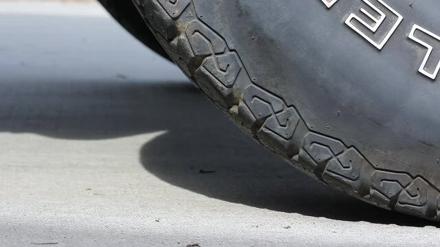Male Hand Moving Rubber Wheel Chock To A Tire On Concrete Multiple Times