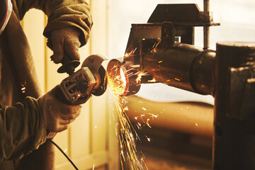 Worker cuts steel with a grinder, close-up