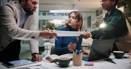 Creative, teamwork or planning with documents in office at night for marketing campaign, design feedback or strategy. Graphic designer, people and discussion for brand development, ideas and overtime