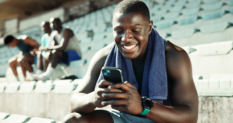 Stadium, man and typing with smartphone for fitness, online communication and scroll on application. Outdoor, male person and smile with mobile for chat message, social media and break for exercise