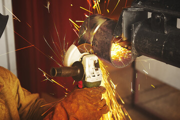 Close-up of worker cutting metal with grinder.
