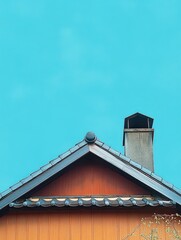 Close-up view of wooden house roof with traditional tiles and chimney against clear blue sky