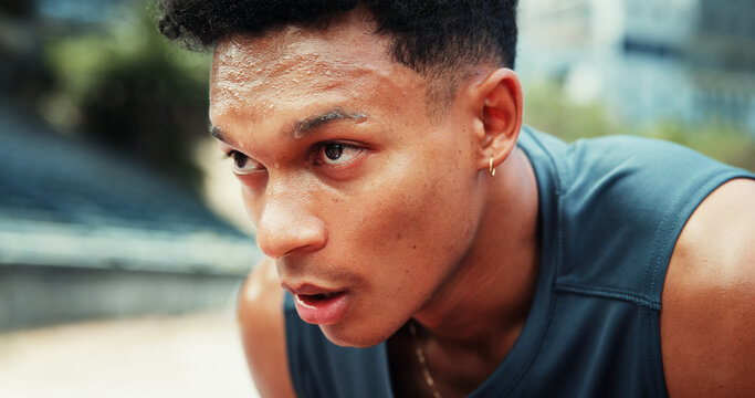 Runner, man and tired with sweating at stadium for running fatigue, endurance challenge and race competition. Fitness, athlete and exhausted with breathing for exercise recovery, workout and resting