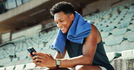 Stadium, man and message with smartphone for fitness, online communication and scroll on application. Outdoor, male person and smile with mobile for typing chat, social media and break for exercise