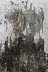 Grungy weathered concrete wall with cracks and stains, exuding a raw, aged texture background