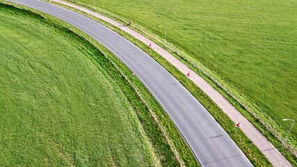 Aerial drone view of asphalt motorway road curve and bicycle lane from above, transportation infrastructure of the Netherlands