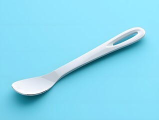 Modern white spoon with a sleek design placed on a light blue surface for culinary, kitchenware, and dining utensils concept