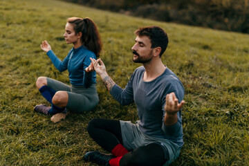 Athletes meditating outdoors in grass field: finding peace and mindfulness