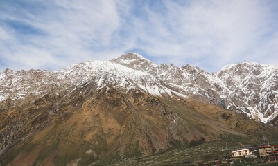 Snow-capped Mountain Range with Village Nestled in the Foothills