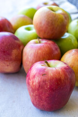 Apples of different varieties such as Granny Smith, Starking, Fuji are on the table