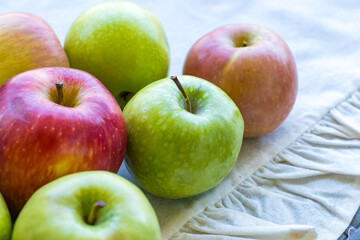 Apples of different varieties such as Granny Smith, Starking, Fuji are on the table