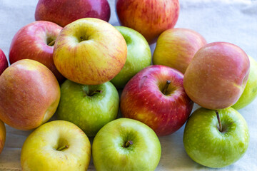Apples of different varieties such as Granny Smith, Starking, Fuji are on the table