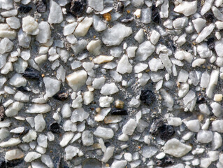A wall with a white and black stone pattern