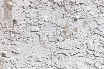 A wall with a lot of cracks and holes