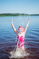 A girl with pink hair is relaxing on a lake on a hot summer day.