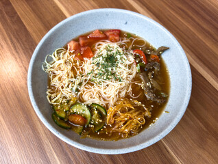 A bowl of soup with noodles, vegetables, and meat
