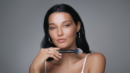 Close-Up Portrait of Woman Holding Makeup Brush for Beauty and Skincare Promo