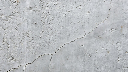 Obraz premium Close up view of a textured light gray concrete wall with prominent cracks running diagonally across its surface