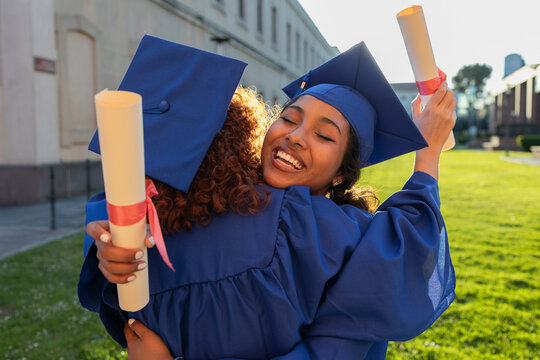 University students celebrating graduation with a joyful hug outdoors