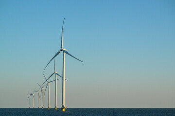 Offshore wind turbines at the end of the day over the ocean