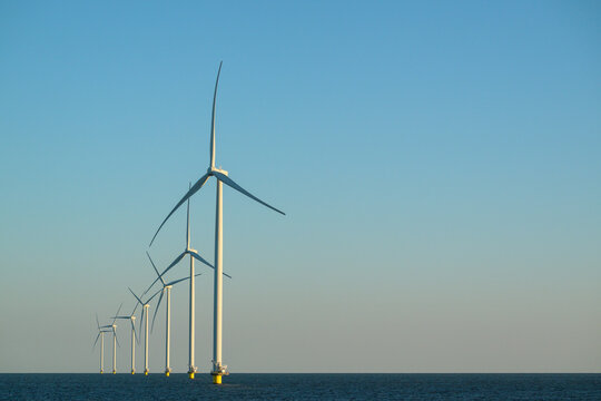 Offshore wind turbines at the end of the day over the ocean
