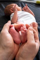 Tender Moment: Adult Hands Holding Newborn Baby Feet