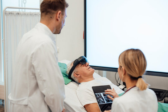 Doctor using virtual reality technology with patient in a medical office - Powered by Adobe