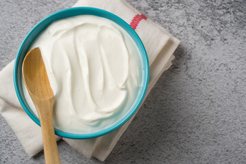 Top view of yogurt in bowl on grey stone table. Healthy eating concept