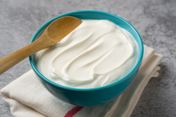 Top view of yogurt in bowl on grey stone table. Healthy eating concept