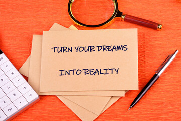 TURN YOUR DREAMS INTO REALITY words written on an envelope on a bright background, along with a...