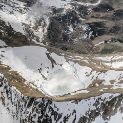 aerial landscape with melting ice on Moro lake, Orobie, Italy