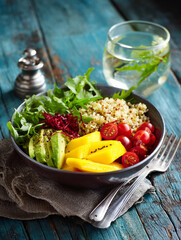 Close up of bowl with quinoa salad with red tomatoes, mango. restaurant background. AI Generative