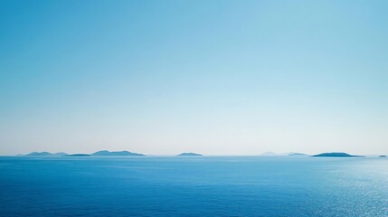 A serene seascape with distant islands under a clear blue sky.