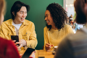 Diverse, multinational friends enjoying coffee and conversation at cafe table