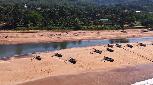 Aerial view circling traditional Dhoni fishing boats, moored on a beach in India