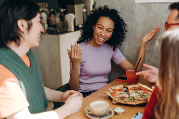 Friends enjoying pizza and conversation at restaurant table