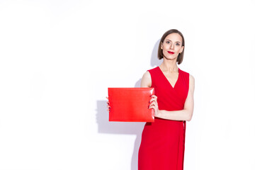 Positive Confident Caucasian Business Woman in Long Red Dress Posing With Red Folder Over White Background.