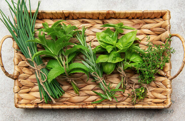 Fresh herbs tied in bundles resting on a woven tray