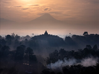 Misty Borobudur temple in the morning with the Merapi, Merbabu and Arjuno mountain in the surroundings. Borodubur is the biggest Buddhist temple in the world that was one of 7 wonders of the worlds.