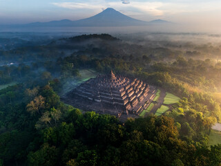 Misty Borobudur temple in the morning with the Merapi, Merbabu and Arjuno mountain in the surroundings. Borodubur is the biggest Buddhist temple in the world that was one of 7 wonders of the worlds.