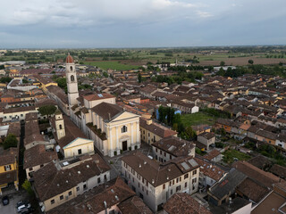 Fototapeta premium sweeping look north over terracotta roofs and shuttered windows of Pontevico historic center, with the slender bell tower of Abbazia dei Santi Tommaso e Andrea Apostoli church rising