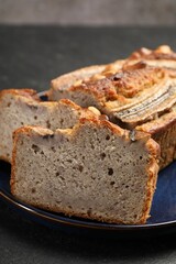 Cut banana bread with nuts on black table, closeup