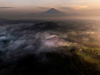 Misty Borobudur temple in the morning with the Merapi, Merbabu and Arjuno mountain in the surroundings. Borodubur is the biggest Buddhist temple in the world that was one of 7 wonders of the worlds.